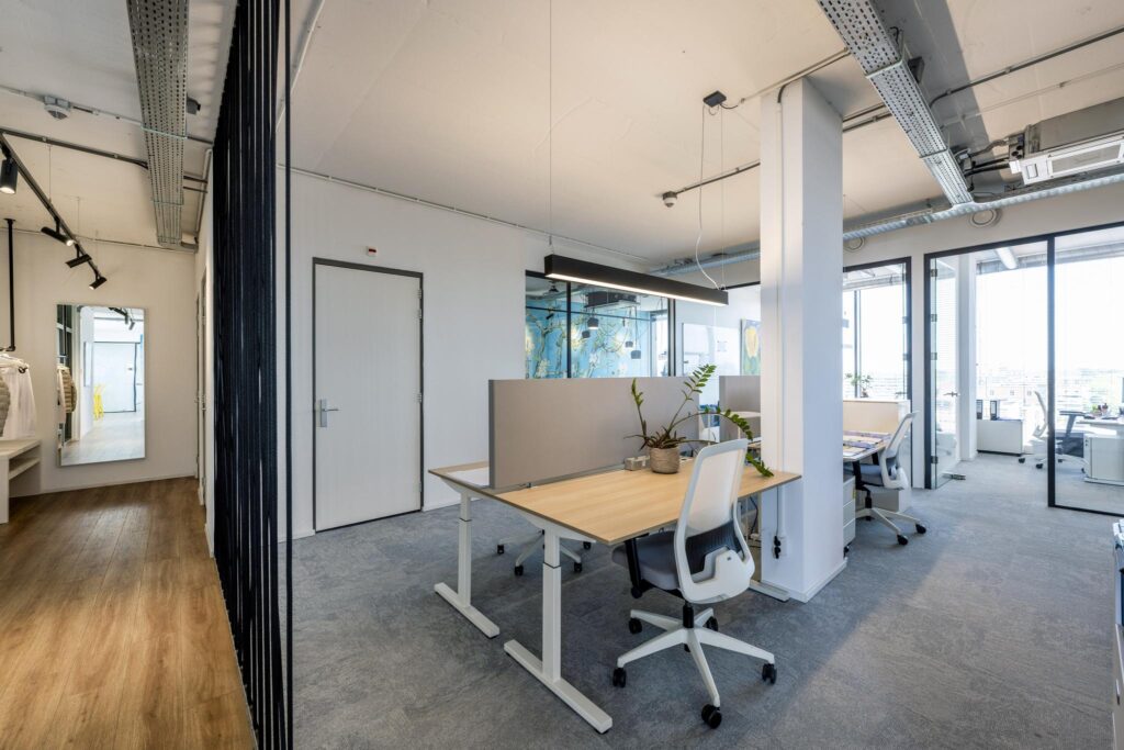 Modern open-plan office with shared desks, ergonomic chairs, and large windows at Elizabeth Cady Stantonplein.